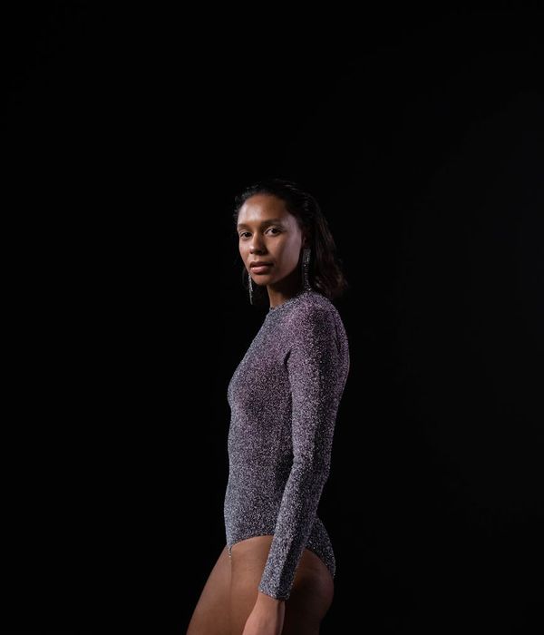 Woman performing a calm yoga pose in a studio with soft lighting.